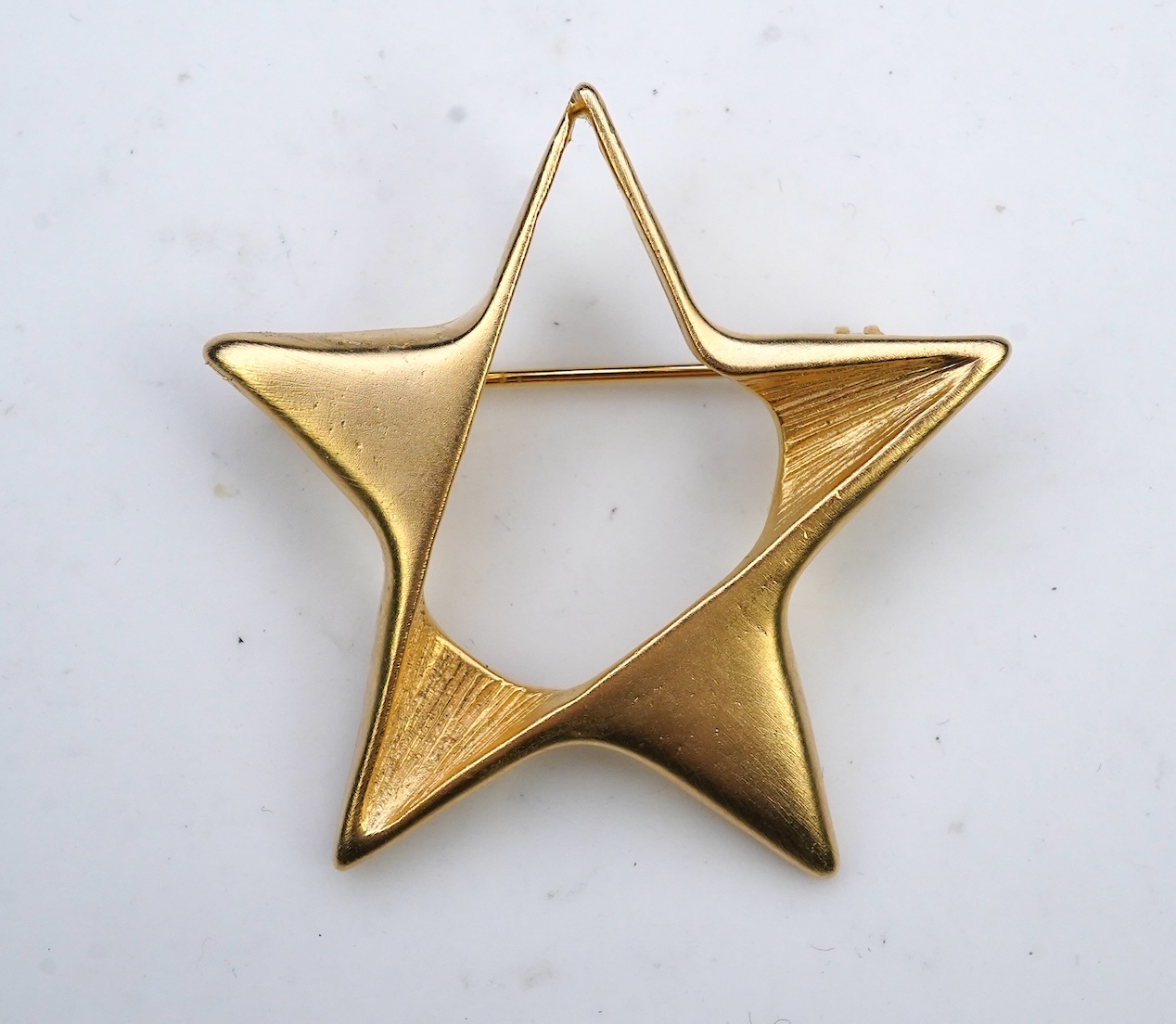 A tarnished gold star brooch in box